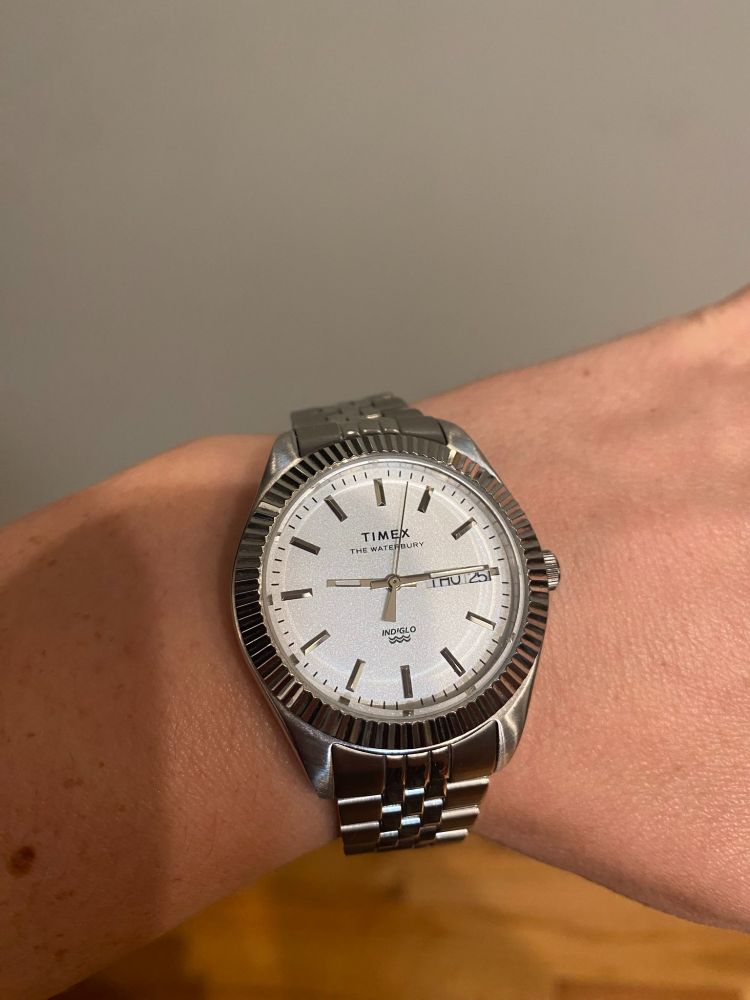 a silver timex watch with a presidential metal bracelet style band. It is a "men's" style designed for woman 