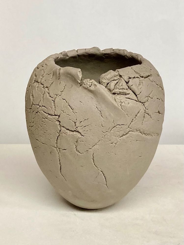 Six inch tall pinched sandy stoneware vase, made from one pound of clay. Lots of surface texture, and a broken uneven rim that documents how the clay responded to the making process. 
