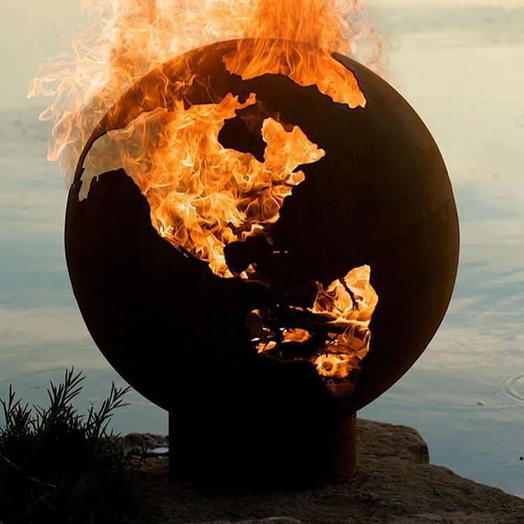 globe shaped fire pit with flames coming out of negative space continents