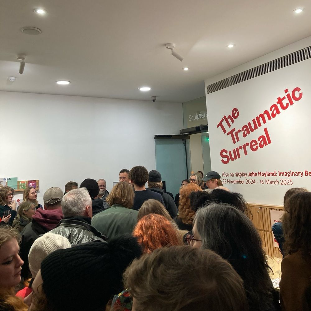 A large group of people listening to speeches at an exhibition opening in the Henry Moore Institute. 