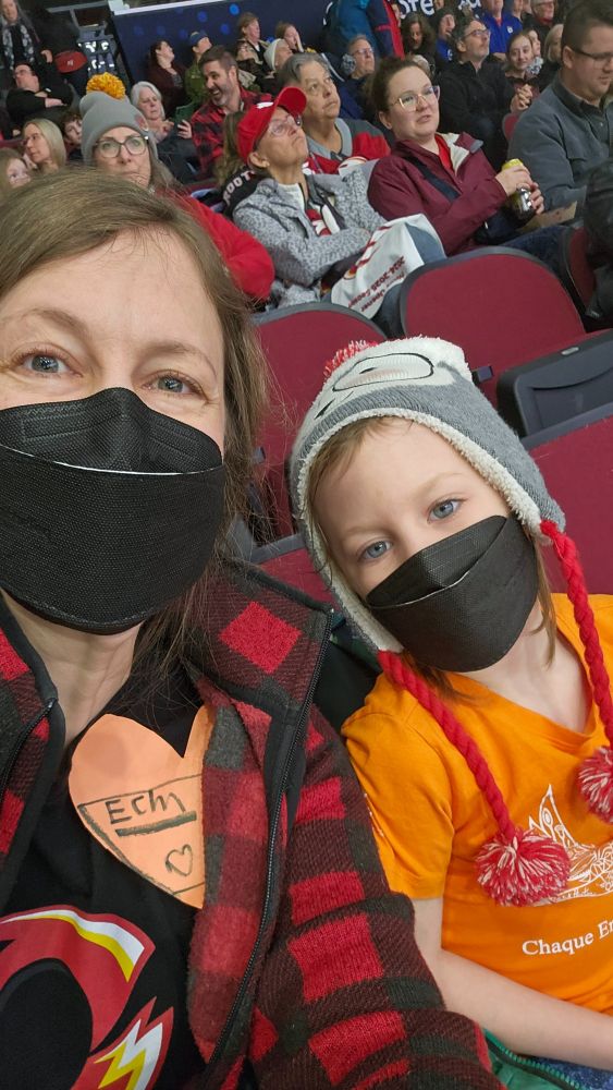 My young son and I, wearing masks at the Ottawa Charge hockey game, and also wearing orange for Indigenous Heritage night.