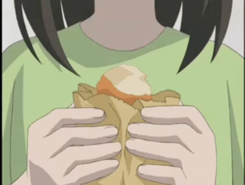 a girl in a green shirt is holding a bag of bread