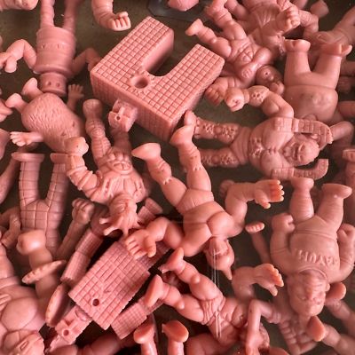 Several Muscle Men figurines scattered over a surface 