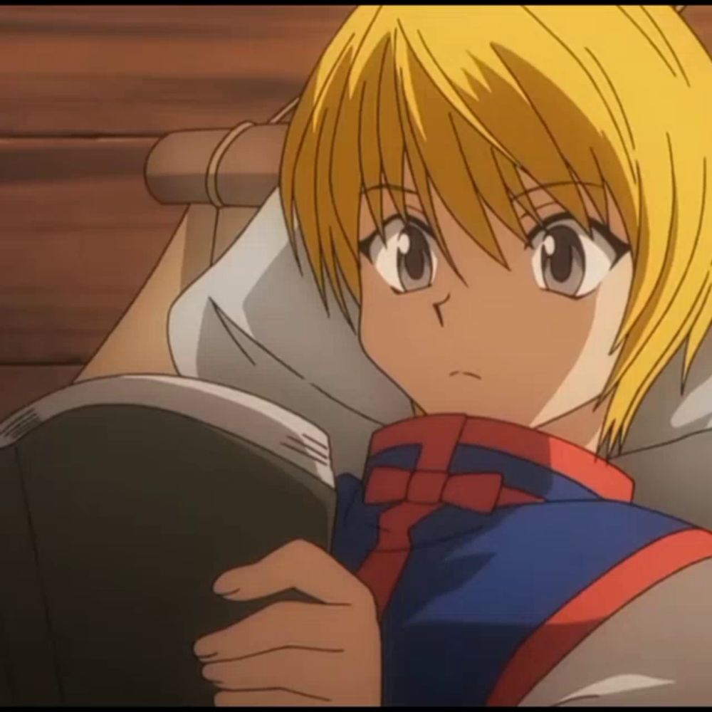 a yellow haired anime character laying on a bed holding a book