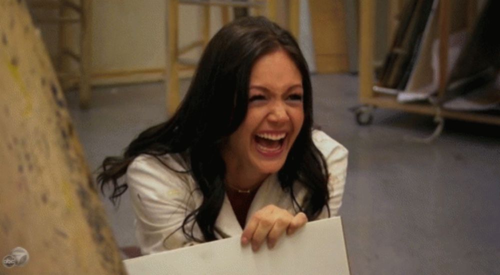 a woman in a white coat is laughing while holding a piece of paper ..