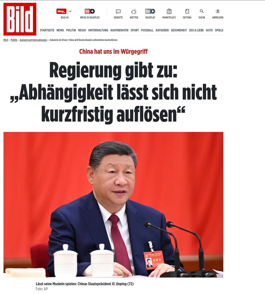 Auf dem Bild ist ein Screenshot eines Artikels der „Bild“-Zeitung zu sehen.

Oben prangt das bekannte rote „Bild“-Logo. Darunter steht in großer schwarzer Schlagzeile:

> „Regierung gibt zu: ‚Abhängigkeit lässt sich nicht kurzfristig auflösen‘“



In roter Schrift darüber:

> „China hat uns im Würgegriff“



Darunter befindet sich ein Foto des chinesischen Staatspräsidenten Xi Jinping, der in einem dunkelblauen Anzug, weißem Hemd und roter Krawatte an einem Tisch mit zwei weißen Teetassen sitzt.
Im Hintergrund hängt ein roter Vorhang, der die Szene dominiert. Vor Xi stehen zwei Mikrofone, er scheint gerade zu sprechen oder zuzuhören.

Die Bildunterschrift lautet:

> „Lässt seine Muskeln spielen: Chinas Staatspräsident Xi Jinping (72)“
Foto: AP



Inhaltlich suggeriert die Seite, dass Deutschland wirtschaftlich stark von China abhängig ist und dass die Bundesregierung diese Abhängigkeit eingesteht, während China selbstbewusst auftritt.