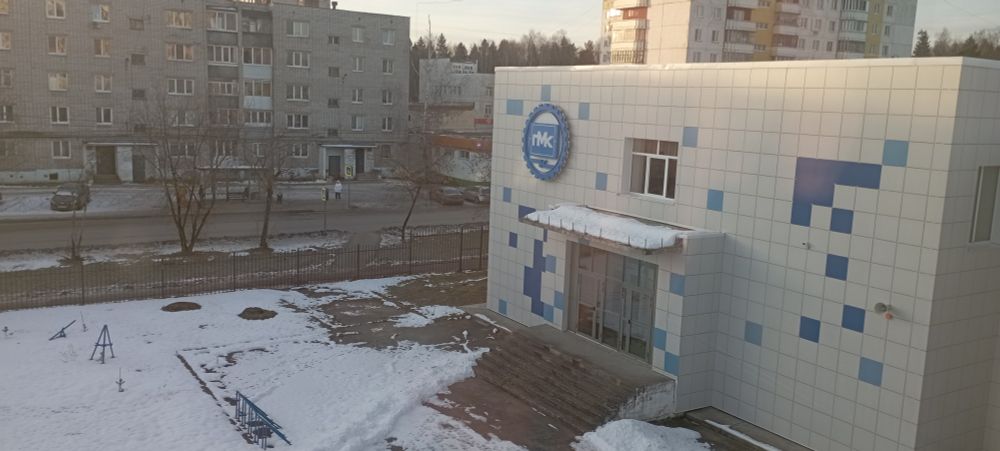 A view on the PMK College building from a third floor window, the logo of the college is in the center of the image.