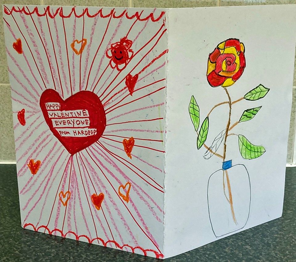 Valentine card folded so you can see both sides. Front side - picture of big red heart with lots of little red hearts. It says Happy Valentine Everyone from Hardeep. Other side - picture of red and yellow flower in a jar.