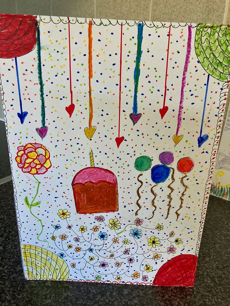 An A4 sheet with many small drawings of balloons, flowers and cake. No text.