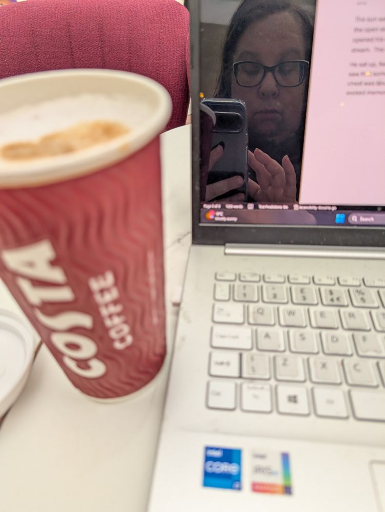 A cup of coffee and the corner of a laptop