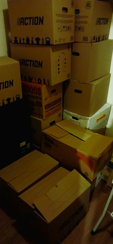 About a dozen big cardboard boxes stacked on top of each other.