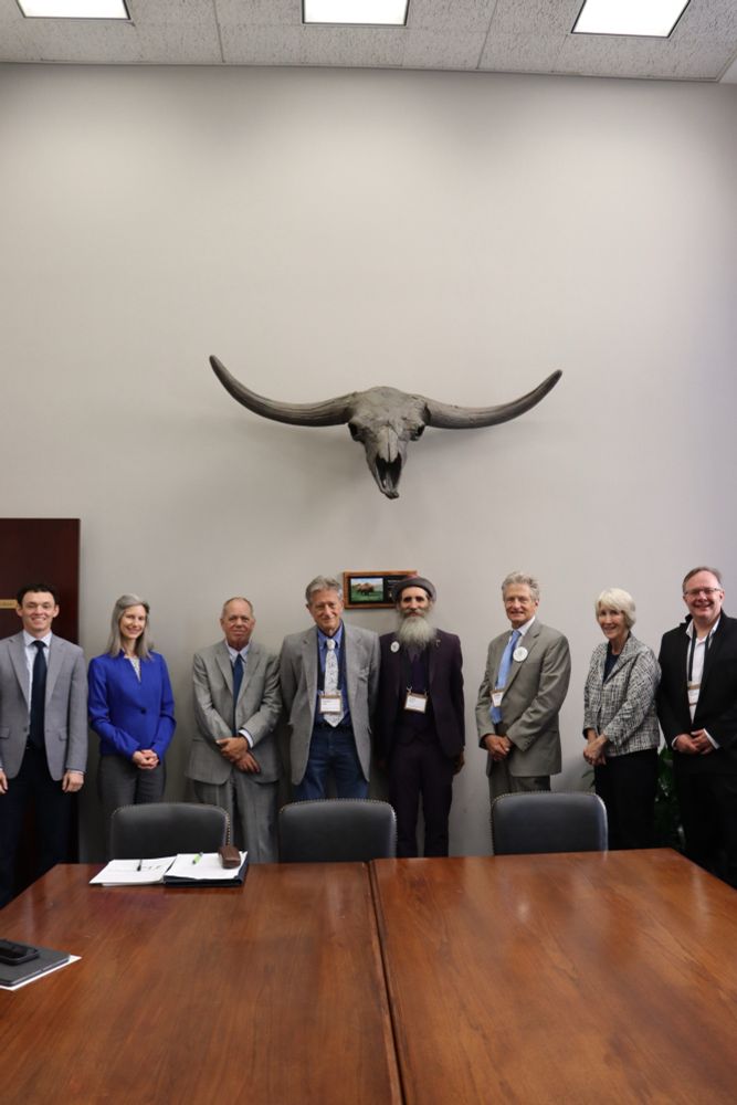 Picture of Citizens Climate Lobby representatives and Senator Hickenlooper staff standing in front of a conference room wall that has a large longhorn cow skull above them.