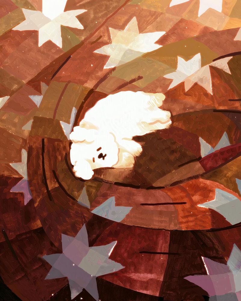 A small white fluffy dog asleep on a brown quilt with white and grey stars. The quilt is bunched up around the puppy, and has a light to dark gradient going on from top to bottom. 
