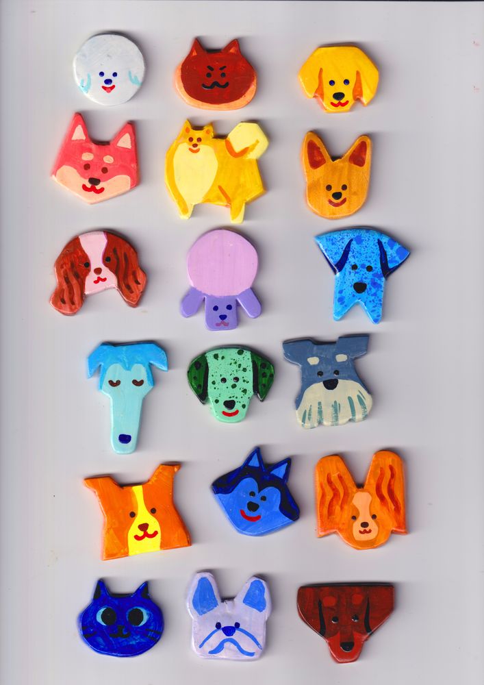 18 little 1-ish" magnets on a white bg arranged in rows of 3. Almost all dogs, almost all just heads. Left to right: White bichon, brown siamese cat, yellow lab, pink shiba, yellow pom (full body), ochre chihuahua, pink and brown ckcs, purple poodle, blue speckled great dane, blue borzoi, green dalmatian, ash blue schnauzer, yellow and orange collie, blue husky, orange papillion, blue cat (not available, just a tester), light grey and blue french bull dog, dark brown dachshund. 
