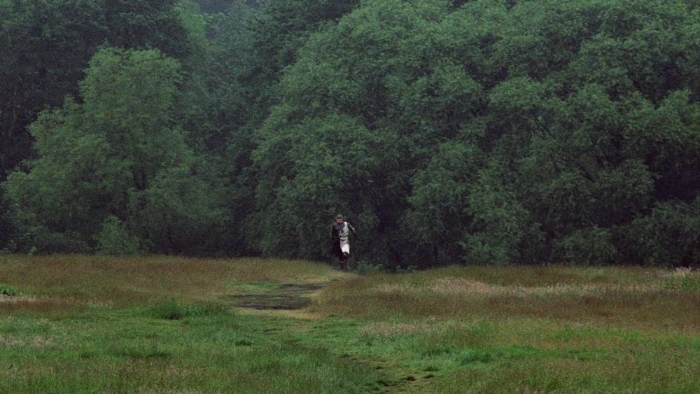 Lancelot in the far distance. Non-diegetic tom-toms can be heard. 