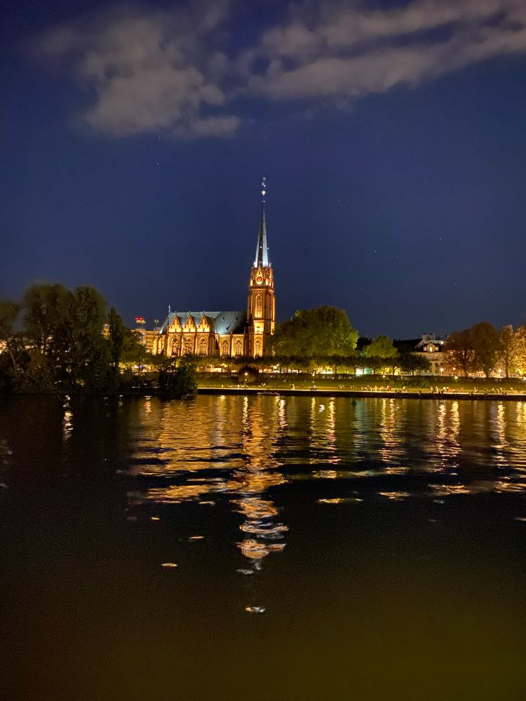 A view at night of a church across the Main river.
