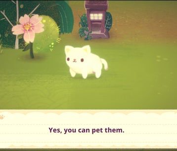 Screenshot of the video game Mineko’s Night Market, with a white cat standing on a green grassy background with a flower, tree and bush in the background and text reading “Yes, you can pet them.”