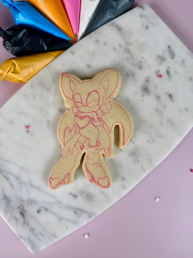 An undecorated cookie with a drawing of a beautiful character on it. 