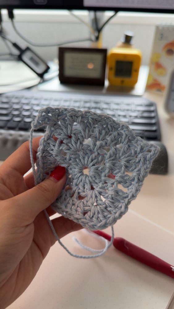 A wonky looking blue crochet granny square.