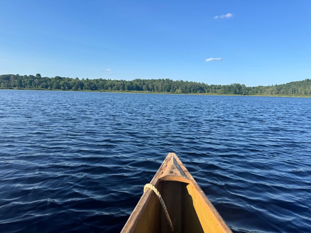 The bow of a canoe on an evening paddle on a pond in Maine