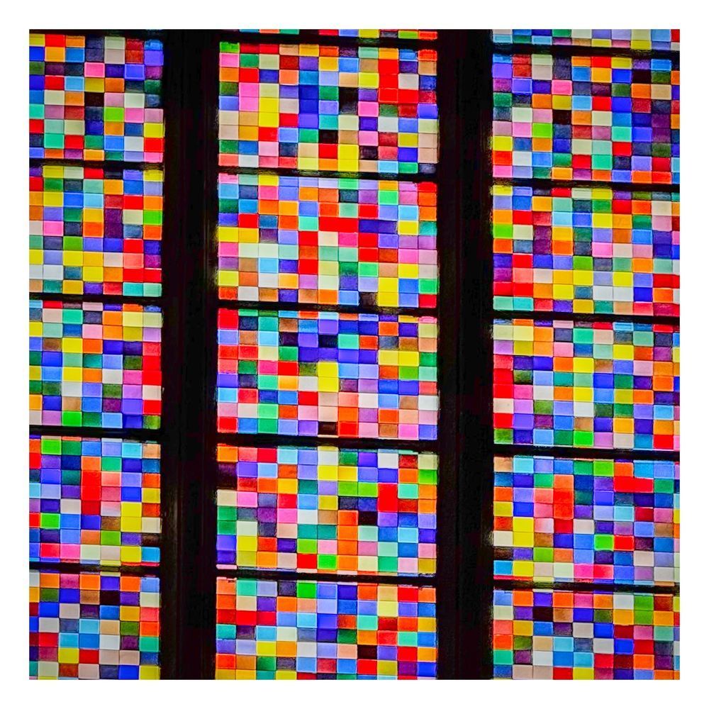 A close-up of a section of stained glass window made up of coloured rectangles.
