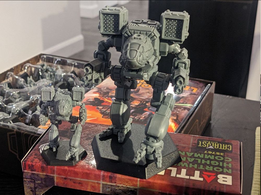 A 4 inch tall battletech mininature next to the standard sized model.