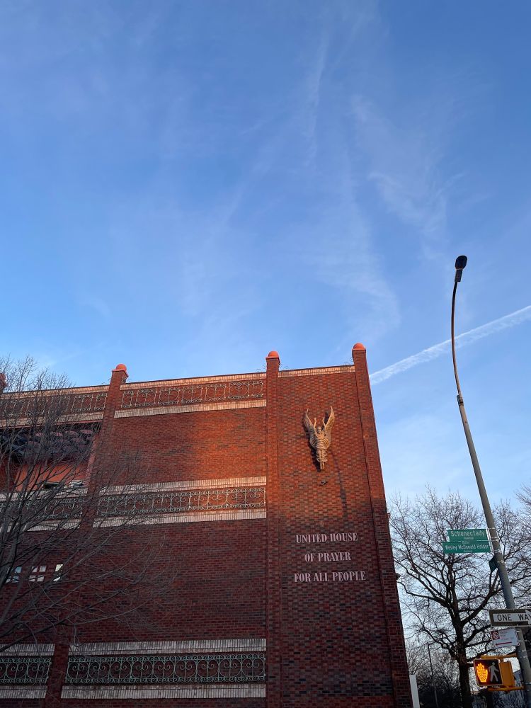 Photo of a large brick building that says on the side: "United House of Prayer For All People."