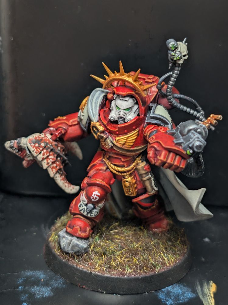 Captain in grav armor painted in Blood Ravens colors, holding a tyranid warrior head. Photo from the front.