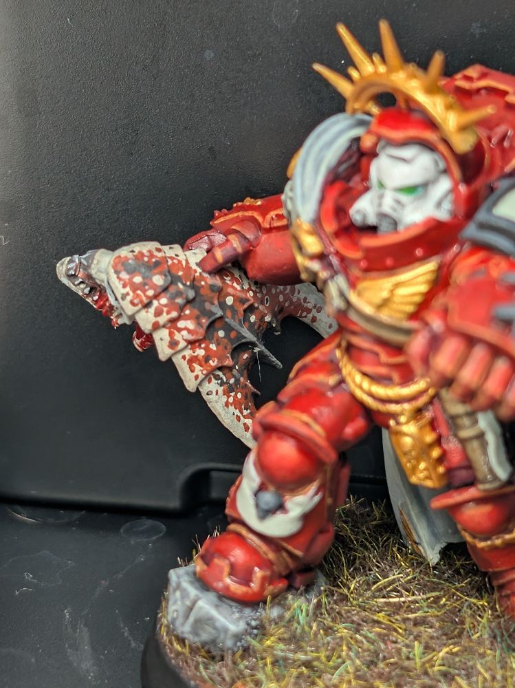 Tyranid warrior head with coconut crab pattern being held by a grav captain 