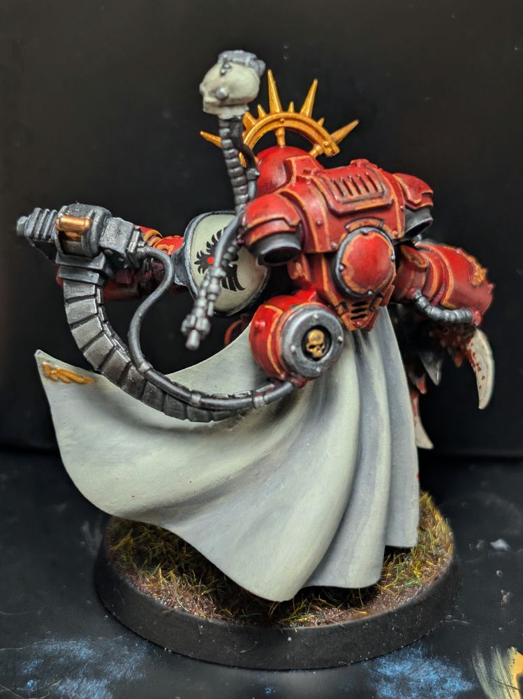 Captain in grav armor painted in Blood Ravens colors, holding a tyranid warrior head. Photo from the rear left.