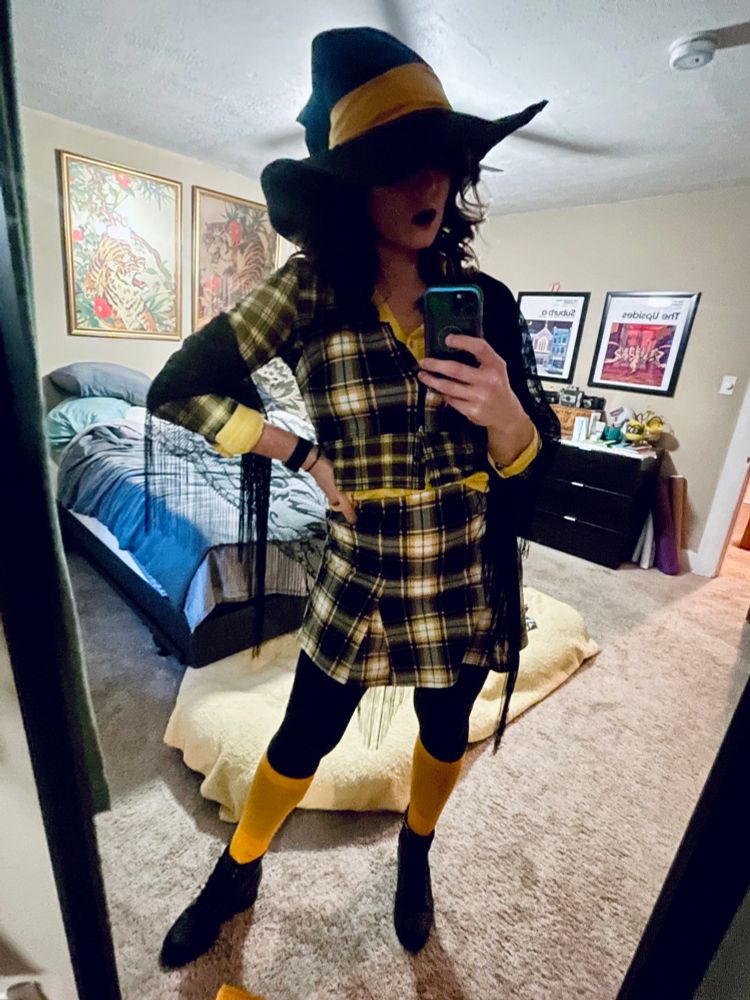 me in a black and yellow plaid skirt with a black and yellow plaid top, yellow knee high socks, black boots, a black shawl and a witch hat i just sewed together out of an old chef coat