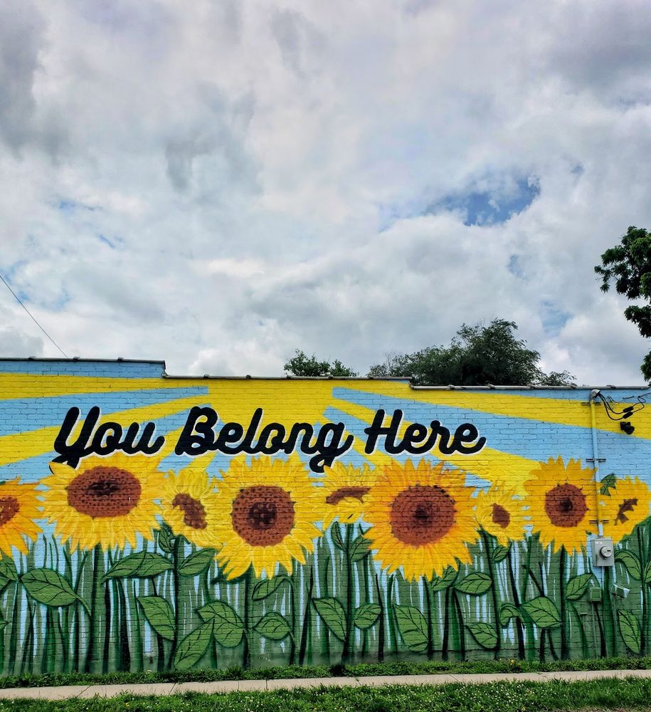 A sunflower mural in Kansas City "you belong here" written above the field of sunflowers