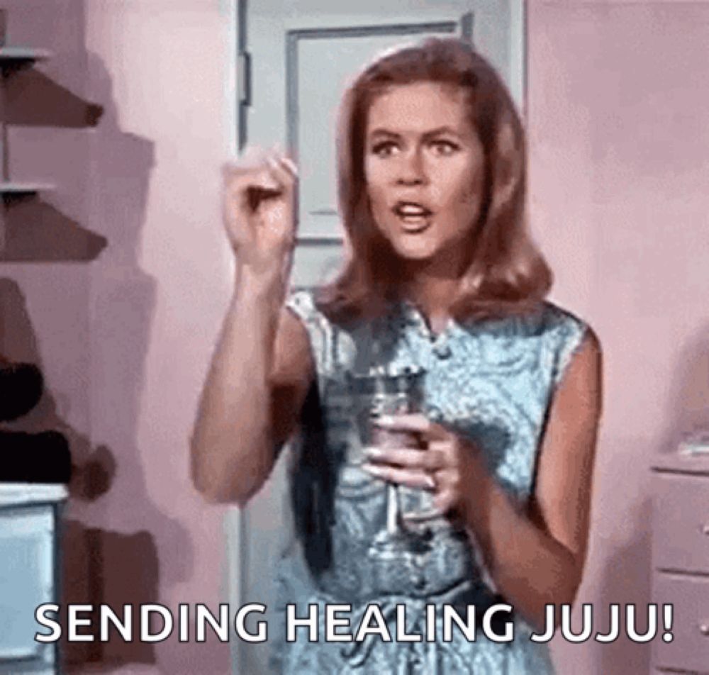 a woman is holding a glass of wine and sending healing juju !