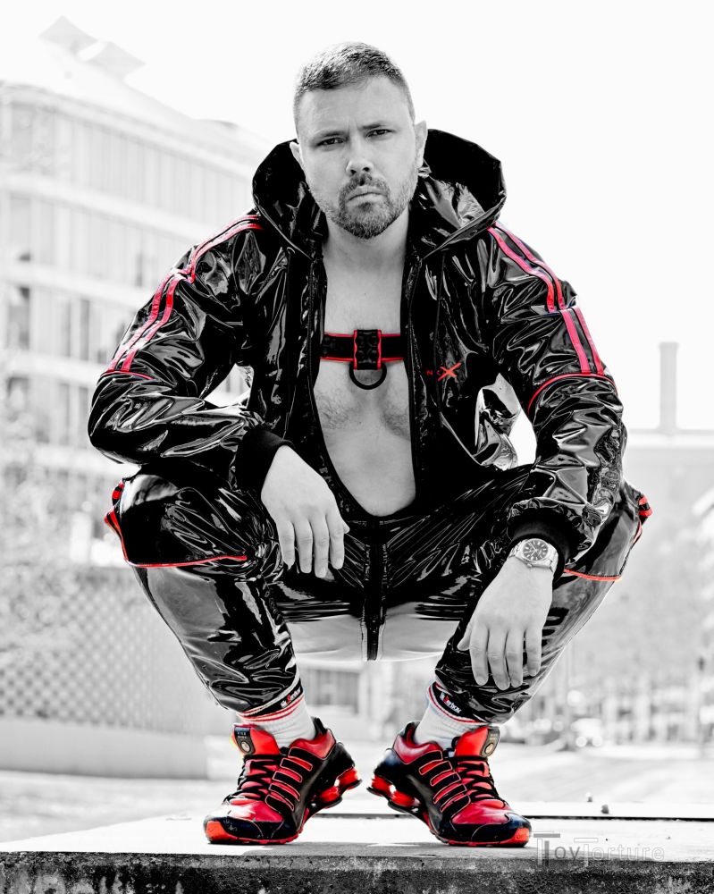 Man in shiny PVC tracksuit, leather bulldog harness and Shox NZ1
