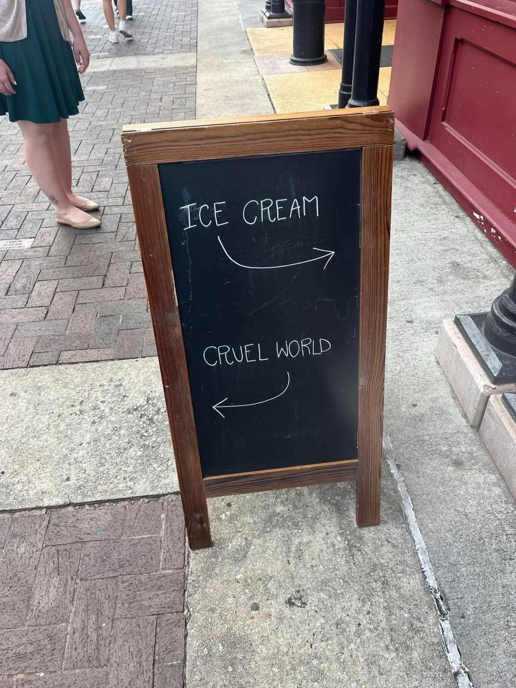 Sign: Ice cream (inside shop) Cruel world (outside)