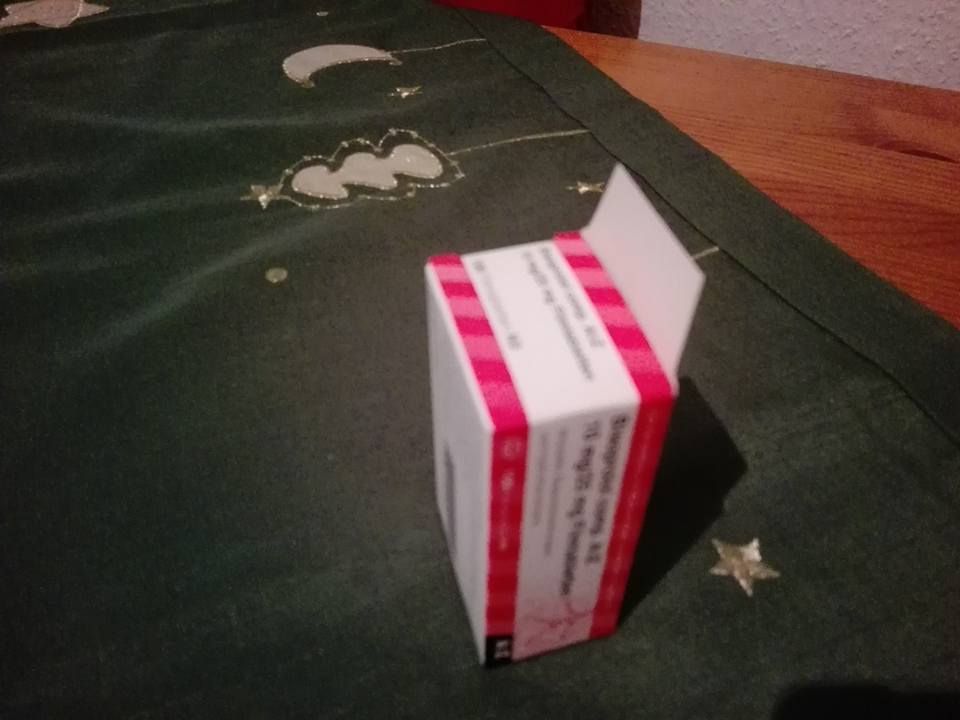 Medikamentenpackung auf Tisch mit Weihnachtsdecke.