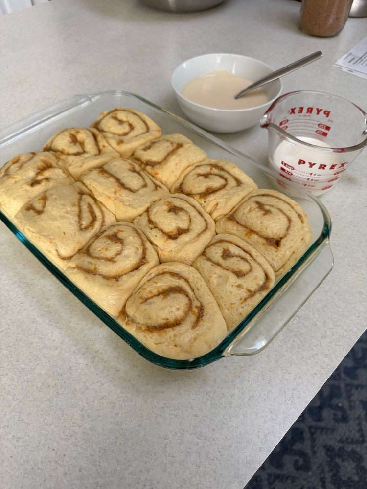 A pan full of orange rolls about to go into the oven