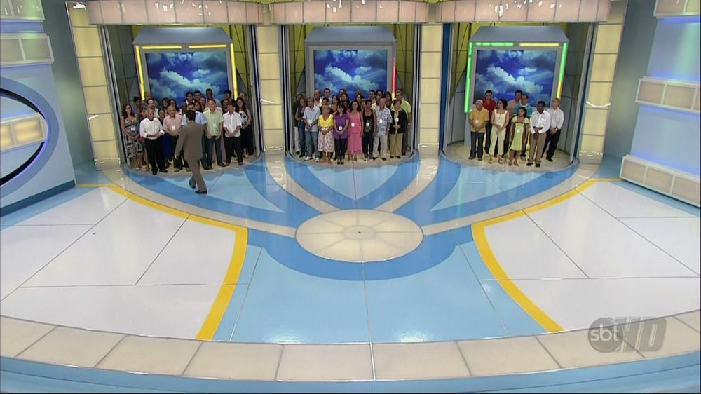 palco do programa Tentação com Silvio Santos com grupos de participantes agrupados por uma das 3 alternativas da pergunta valendo prêmio