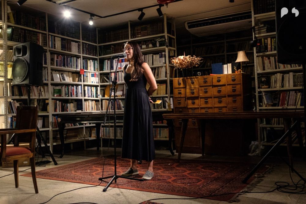 Image of Huda Fakhreddine reciting poetry at the Barzakh Bookshop surrounded by bookshelves in the background.
Photography: Rita Kabalan