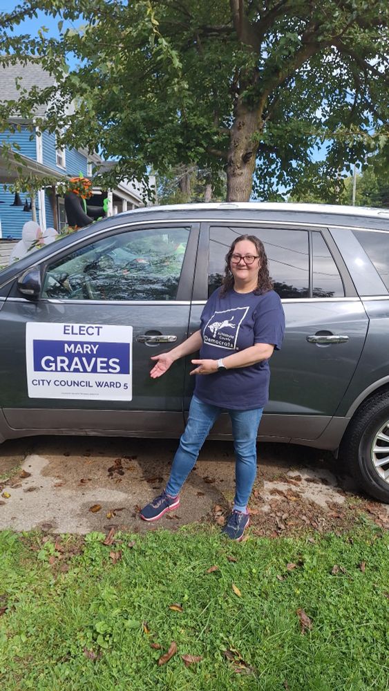 Me standing next to my gray Buick pointing out my new magnetic sign.