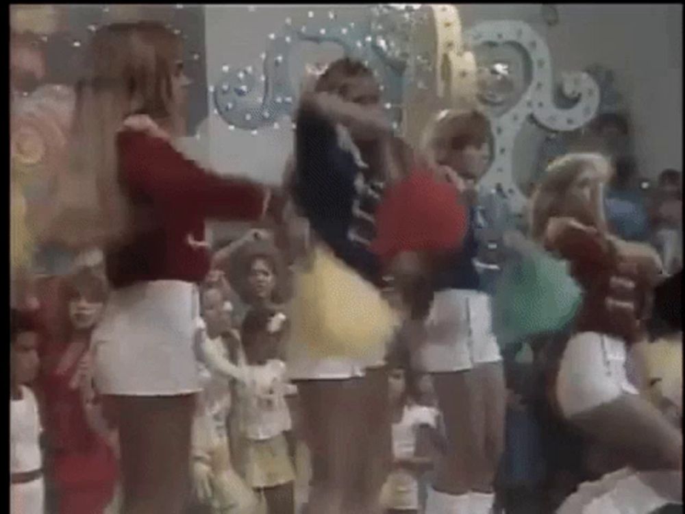 a group of young girls are dancing in front of a crowd of people .