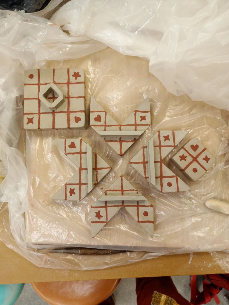 Photo of the same piece still in progress (unfired). The 6 pieces that stack and interlock together have been separated to show how the form functions.