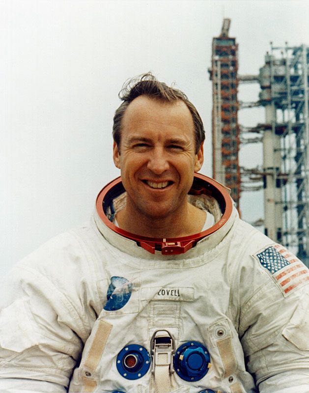 Jim Lovell posing for a picture in front of the Saturn V rocket