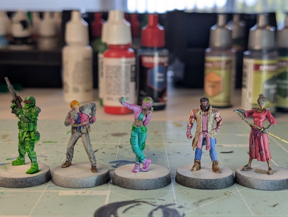 A group of five cyberpunk themed minis, with a camo green operator, a businessman with a grey suit and red shirt, a vaporwave selfie taker, a buff dude with big muscles, and a red dress samurai lady