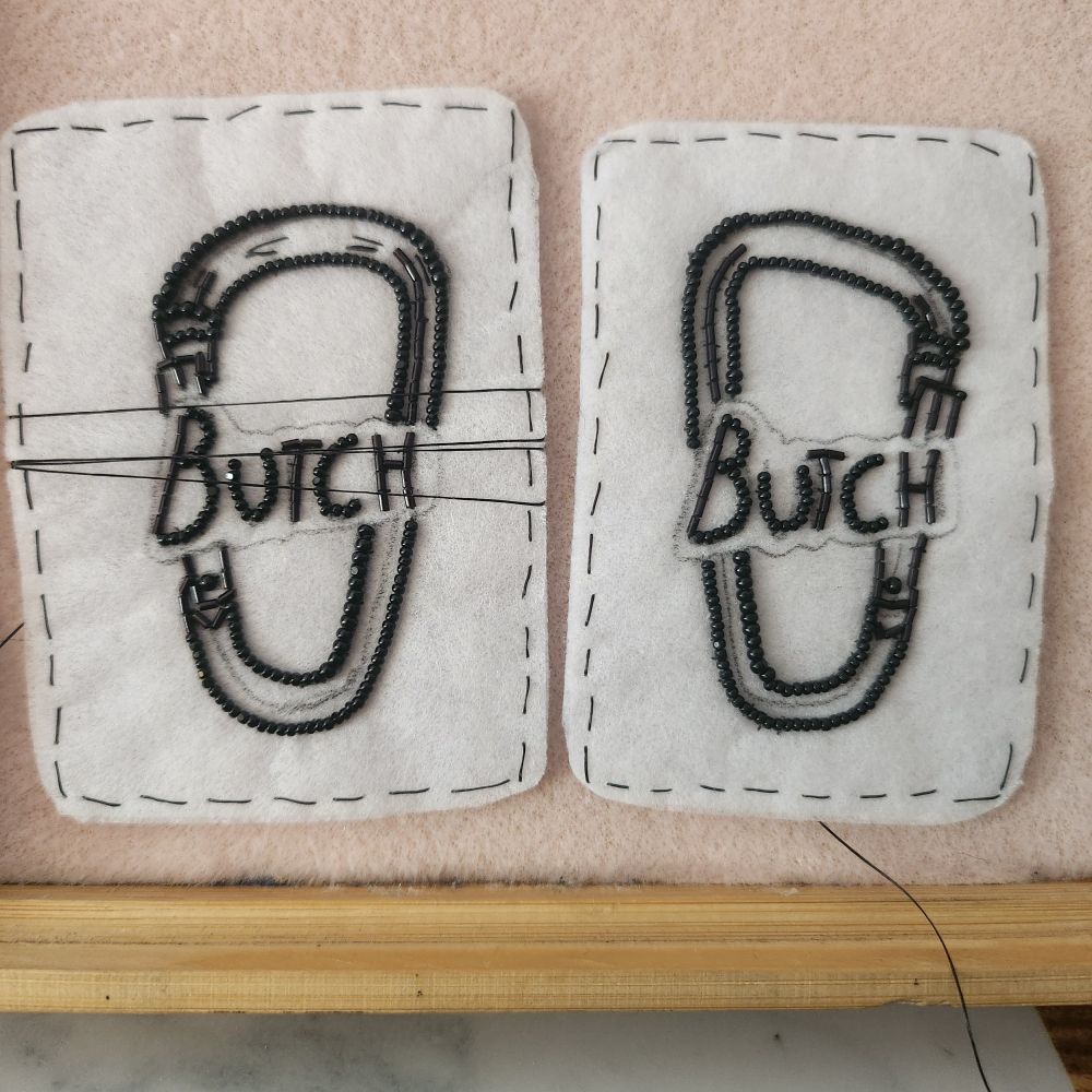 Beaded carabiner earrings with butch written on them 