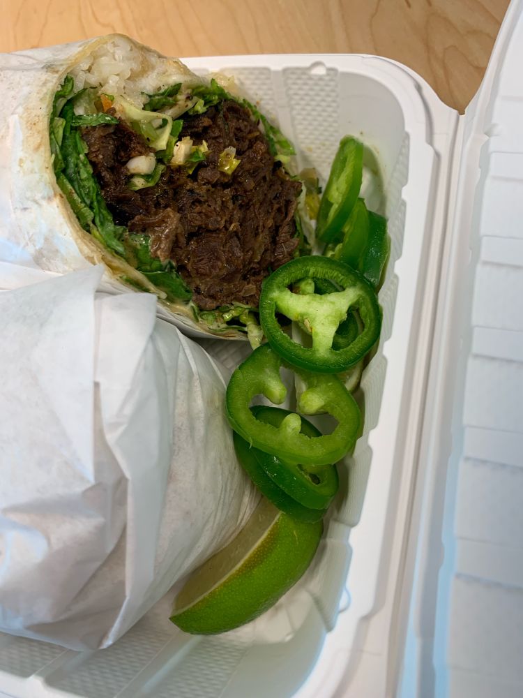 This is a close up shot of the Bulggorito with a side of fresh sliced Jalapeno and lime slice.