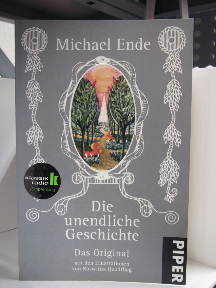 Das hellgraue Buchcover wird von floralen Elemente geziert - mittig erscheint ein mit Schlangen gerahmter Spiegel, welcher den Blick auf eine zentrale Szene im Buch eröffnet: ein von Bäumen und Sträuchern gesäumter Pfad, der von zwei Einhörnern und mehreren Vögeln bewacht wird, führt in das Reich der Kindlichen Kaiserin im Elfenbeinturm.