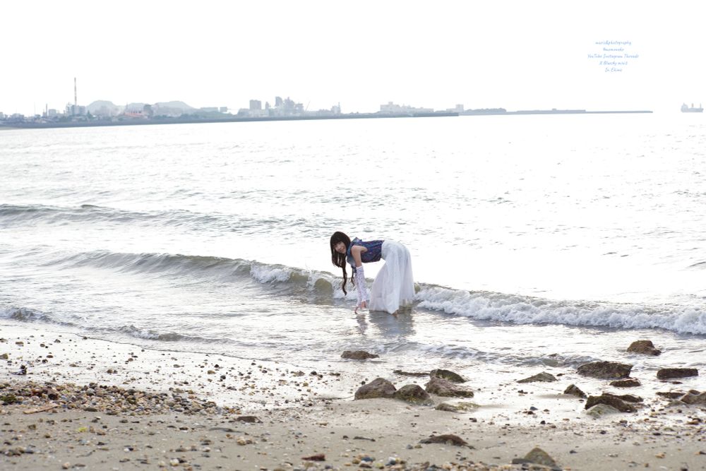 夏の夕暮れ時少し薄曇りだった空の下で着ていた服のまま海に入る女性