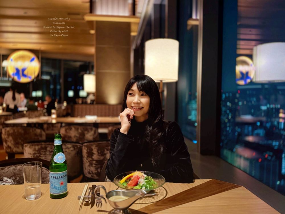 東京高輪ゲートウェイニュウマン高層階でディナー　窓からは美しい夜景、遠くにはレインボーブリッジを眺める サラダから始まるコース料理にワクワクする女性