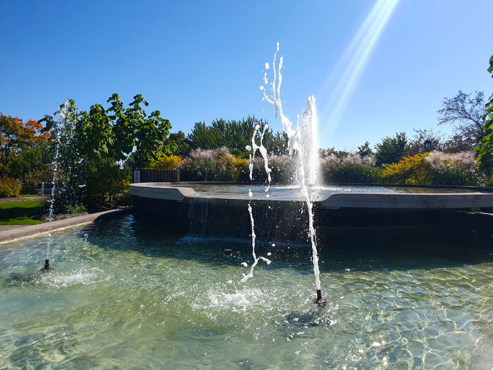 A large fountain with glare from the sun